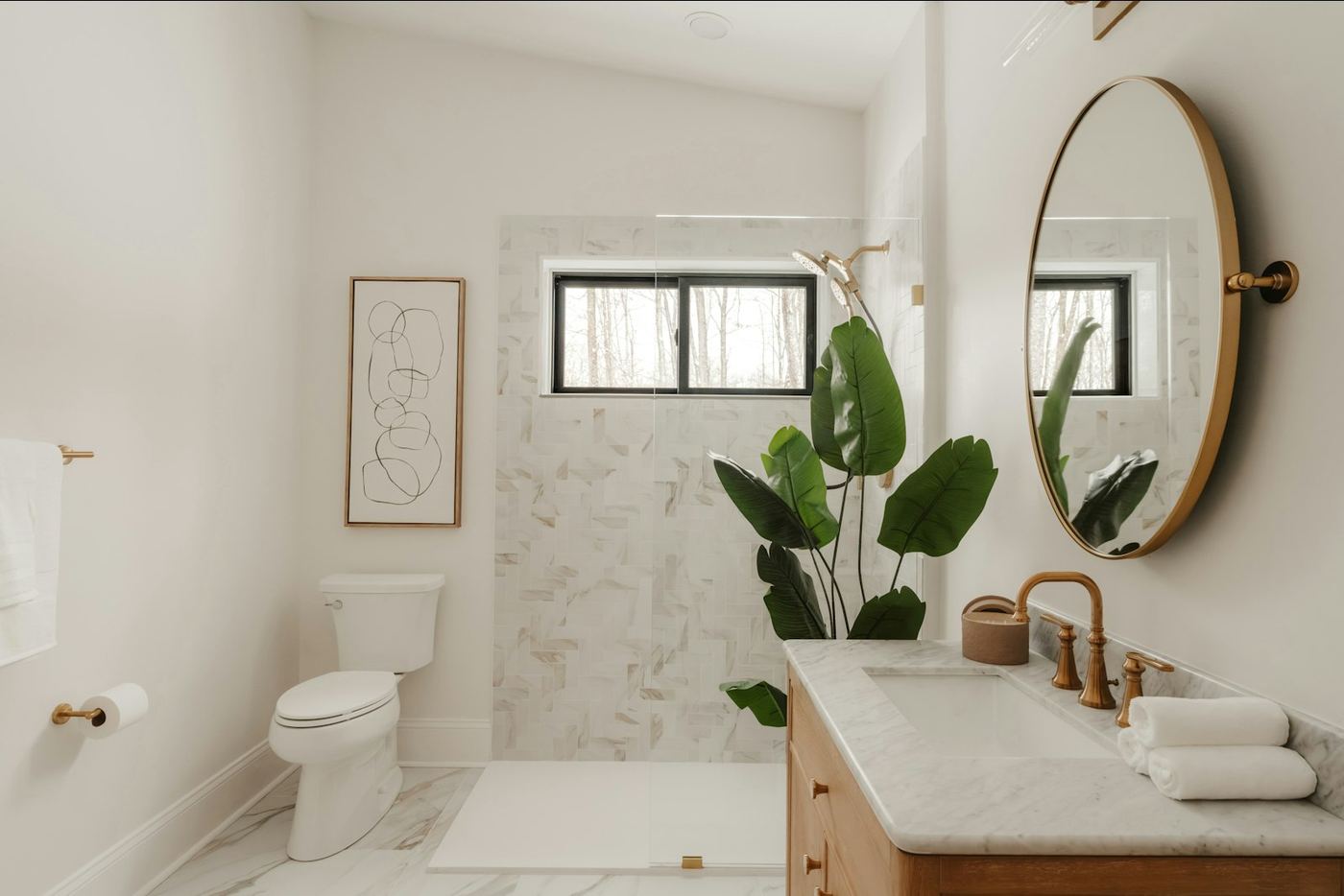 A bright modern bathroom with a round mirror and a large plant